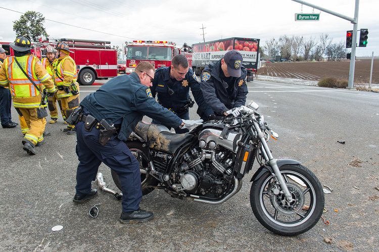 Officers lifting motorcycle involved in hit and run accident